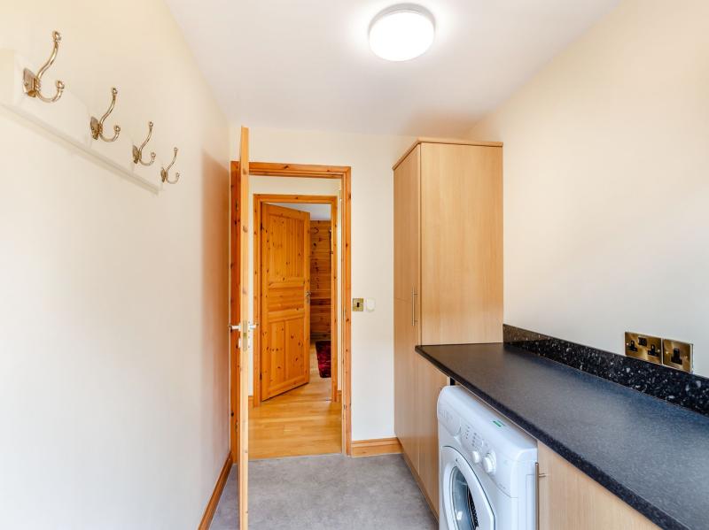 Utility room with coat hooks and washing machine